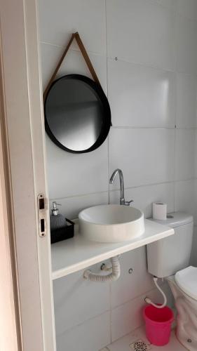 a bathroom with a sink and a mirror on the wall at Aprt com ar varada conjugada,piscina in Aracaju
