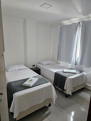 two beds in a room with white walls at Zanotti's House in Santa Teresa