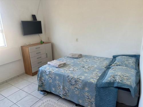a bedroom with a bed and a dresser and a television at Loft Pedra Branca - Unisul in Palhoça