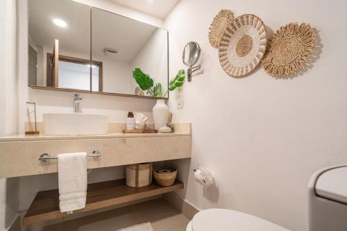 a white bathroom with a sink and a mirror at Oceanfront Paradise Beach Resort Escape in San Felipe de Puerto Plata