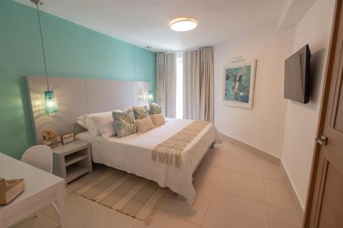 a bedroom with a bed with a blue wall at Oceanfront Paradise Beach Resort Escape in San Felipe de Puerto Plata