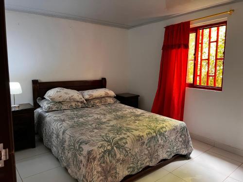 a bedroom with a bed and a red window at La TOLVA Café & experiencia in Pijao