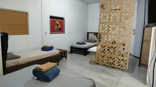 a room with two beds in a room with a partition at Studio Apto Central próximo a Orla in Fatima do Sul