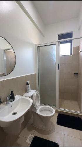 a bathroom with a toilet and a sink and a shower at Pearl Escape in Entebbe