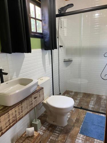 a bathroom with a toilet and a sink and a shower at Chalé Alpino Apiúna in Apiúna