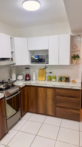 a kitchen with white cabinets and a stove at Amatista Apartment in Cusco