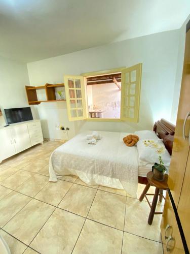 a bedroom with a white bed and a window at Apto com garagem em Diamantina in Diamantina