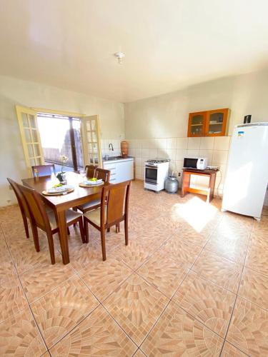 a kitchen with a table and chairs and a refrigerator at Apto com garagem em Diamantina in Diamantina