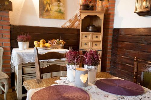 una mesa con platos púrpura y flores en ella en Labirynt, en Łomża
