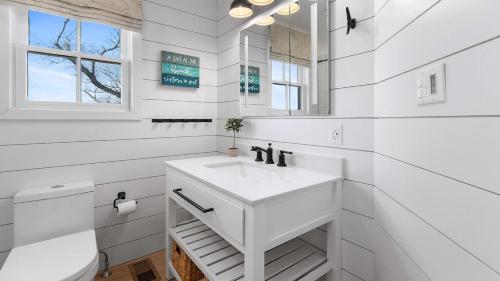 a white bathroom with a sink and a mirror at Summer Winds Sanctuary in Cape May
