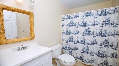 a bathroom with a toilet and a sink and a mirror at Illinois Avenue Hideaway in Cape May
