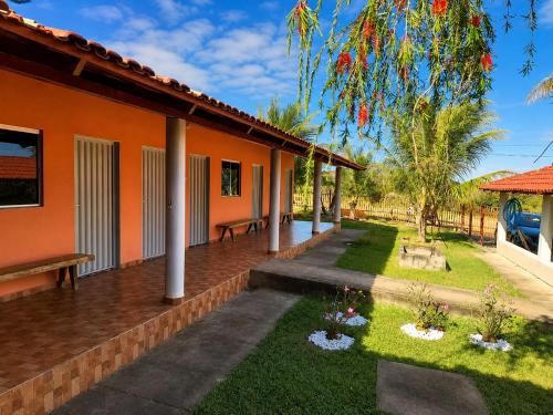 an orange house with a patio and a yard at Pousada Serra Dourada Mossâmedes in Mossâmedes