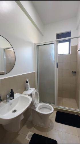 a bathroom with a toilet and a sink and a shower at Pearl Escape in Entebbe