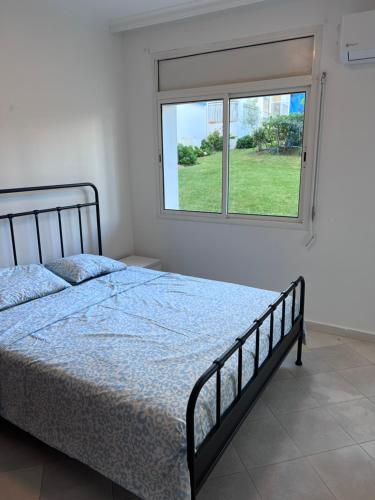 a bedroom with a bed and a window at Apparemment marina smir in Marina Smir
