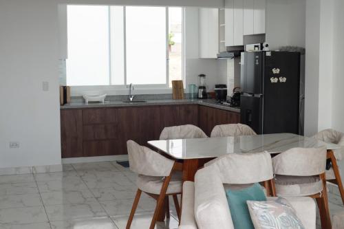 a kitchen with a table and chairs and a refrigerator at Ohana's Beach House in Punta Negra