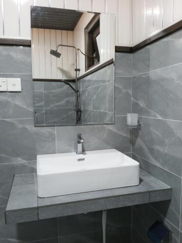 a bathroom with a white sink and a mirror at Ella green stay in Ella