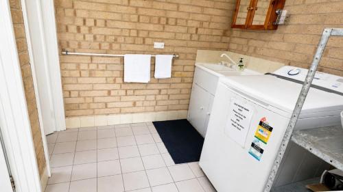 a bathroom with a sink and a washing machine at At Busso Cabin 56 in Broadwater