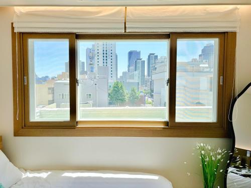 a window with a view of a city skyline at Fine On Stay Jeonpo in Busan