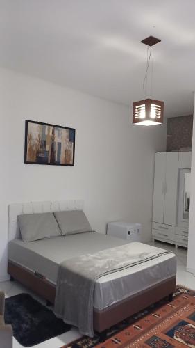a bedroom with a bed and a pendant light at Hospedaria Rancho Pérola in Guanambi