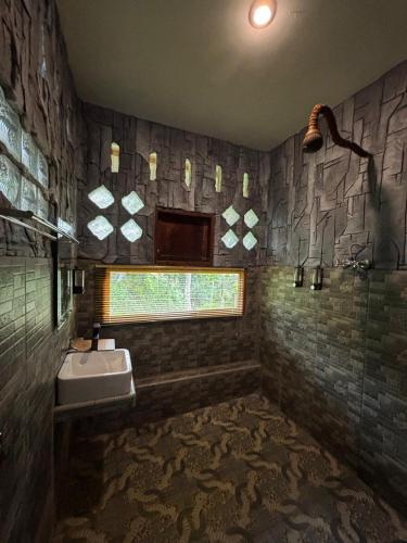 a bathroom with a sink and a window at On The Rocks Bungalows, Restaurant and Jungle Trekking Tours - From May to September only stay here if you are booking jungle treks with us - feel free to contact us about our Jungle Trekking services in Bukit Lawang