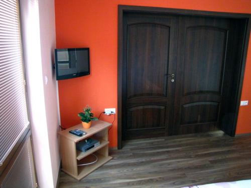 an orange room with a door and a tv at Motorest Eso in Vlčkovce