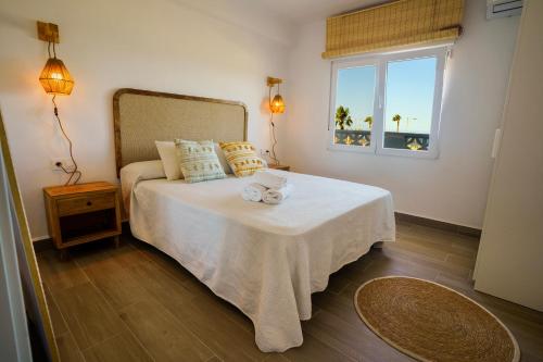 a bedroom with a bed with a table and a window at Ap Turísticos Marea - Frente al Mar in Mojácar