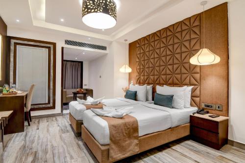 a hotel room with a large bed and a table at Kzar Central in Kolkata