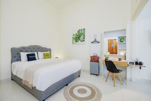 a bedroom with a bed and a desk and a chair at Urbanview Darmo Residence Bandung in Bandung