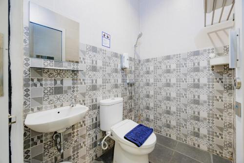 a bathroom with a toilet and a sink at Urbanview Darmo Residence Bandung in Bandung