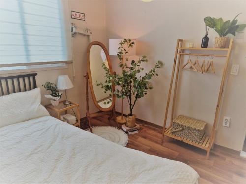 a bedroom with a bed and a mirror on the wall at 스미다 stay in Bucheon