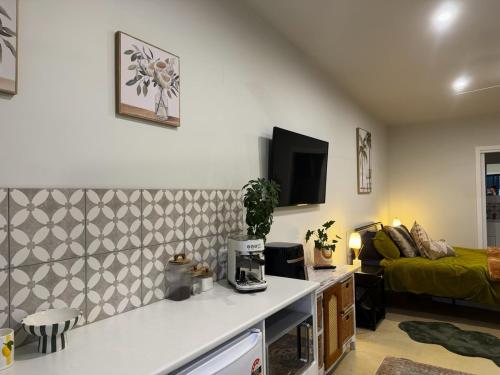 a living room with a kitchen and a couch at Shady Lane - Wallagoot in Jellat Jellat
