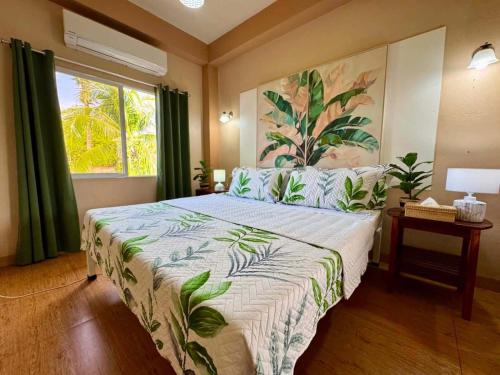 a bedroom with a large bed and a window at Bananaland Cottages in Panglao Island
