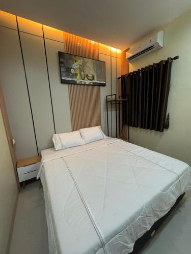 a bedroom with a large white bed in a room at Omah Tentrem Magelang in Magelang