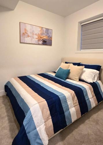 a bedroom with two beds with blue and white sheets at Mountain Views, Premium Coquitlam Stay, Minutes to Transit in Coquitlam