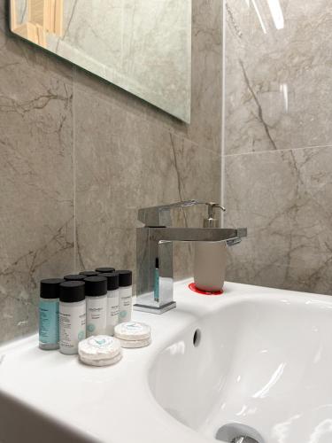 a bathroom sink with bottles ofodorizers on it at Chromata Penthouse Apartment in Paralimni