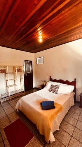 a bedroom with a large bed with a wooden ceiling at Casa Surya Paraty in Paraty