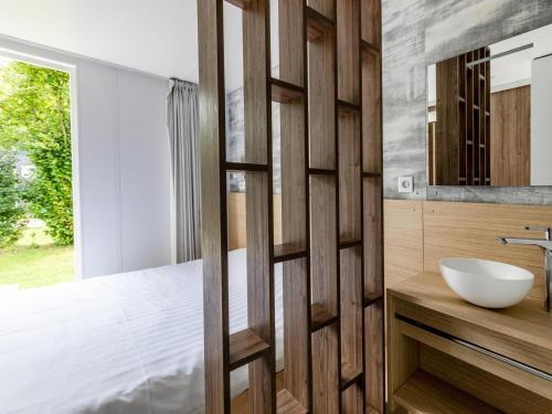 a bathroom with a wooden wall next to a sink at Chalet in Baalse Hei with Modern Comforts in Turnhout