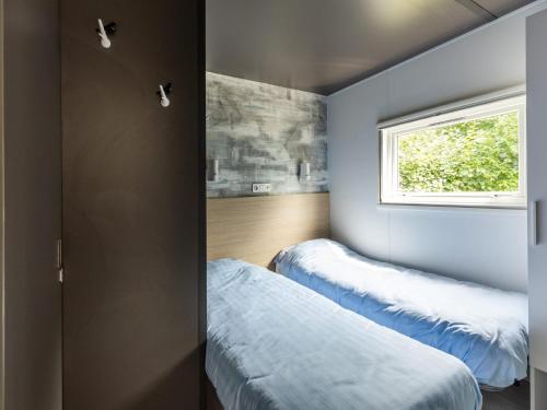a bedroom with two beds and a window at Chalet in Baalse Hei with Modern Comforts in Turnhout