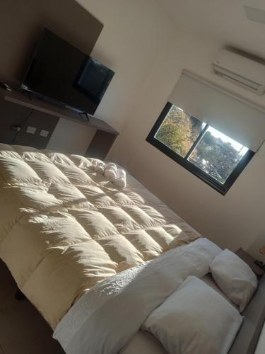 ein Bett in einem Zimmer mit Fenster in der Unterkunft Lya in El Palomar