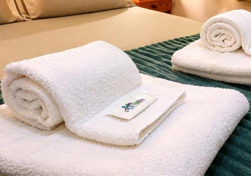two white towels are sitting on a bed at El Cantaro in Villa Elisa