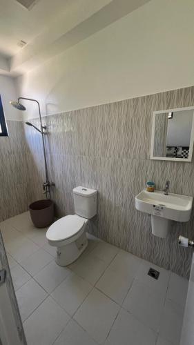 a bathroom with a toilet and a sink at Belga Boarding House in Guimaras