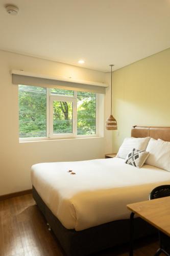 a bedroom with a large bed and two windows at 574 Hotel in Medellín