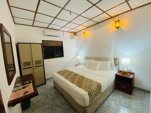 a bedroom with a bed with a zebra print blanket at Sun and Waves Beach Cottage Ahungalla in Ahungalla