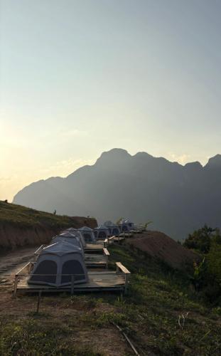 a row of tents on a hill with mountains in the background at Nongkhiaw Camping 360 c top mountain view in Nongkhiaw