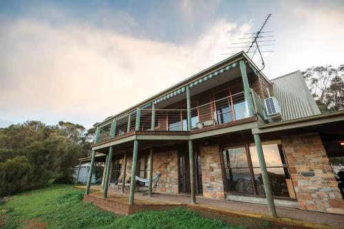 a large brick house with a balcony on top of it at Possum Ridge in Muston