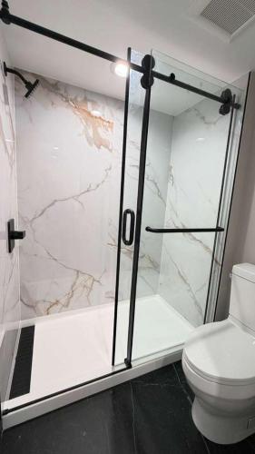 a bathroom with a shower and a toilet at Harbor Bay Inn in Costa Mesa