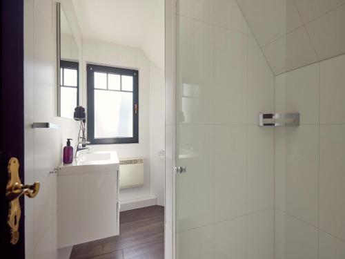 a white bathroom with a shower and a sink at Doppelhaushälfte im Naturresort Drewitz in Drewitz