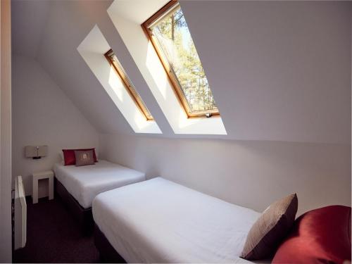 a room with two beds and two windows at Doppelhaushälfte im Naturresort Drewitz in Drewitz