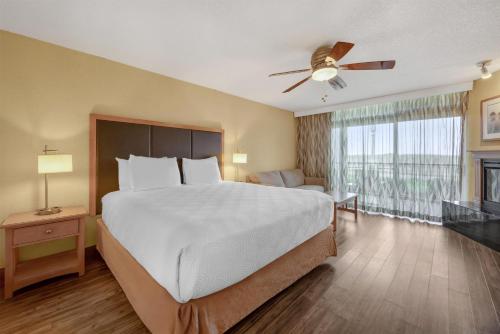 a bedroom with a large bed with a ceiling fan at Best Western Plus Ocean View Resort in Seaside
