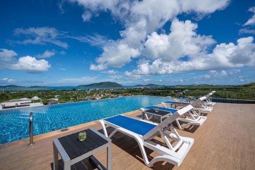 a group of lounge chairs and a swimming pool at The View Rawada Phuket in Rawai Beach